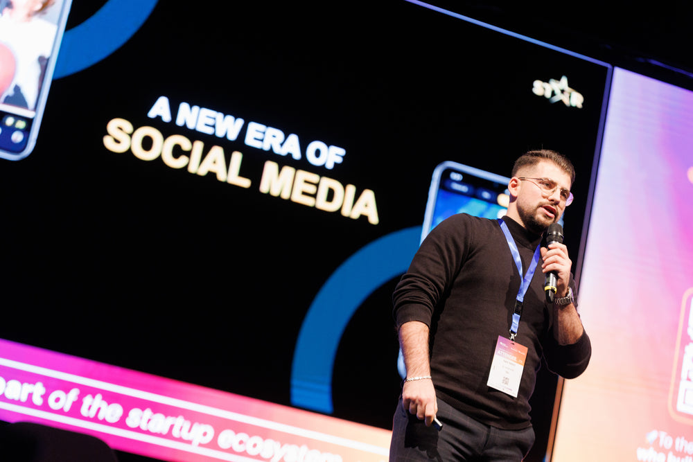 Founder mid-pitch, microphone in hand, mid-launch.
