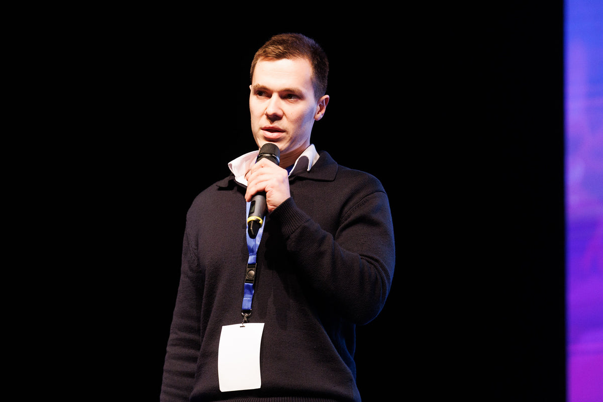 Founder mid-pitch under the qualifier spotlight.